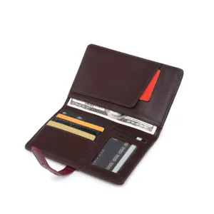 Vista dettagliata del portafoglio per passaporto in pelle marrone con fessure e chiusura.