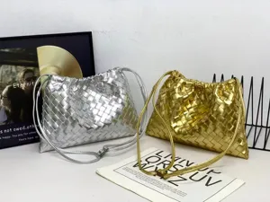 Close-up of metallic silver and gold woven leather shoulder bags with drawstring design.