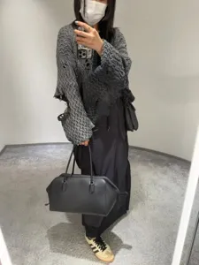 Minimalist black leather bowling bag, large capacity tote shoulder bag for women commuting daily.