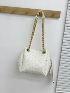Detail de sac bandouliere en cuir tresse blanc, bandouliere chaine elegante et quincaillerie.