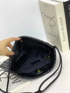 Black woven leather bucket bag with drawstring closure and large capacity daily use.
