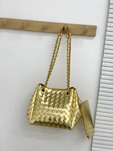Vue détaillée du sac seau en cuir tressé avec bandoulière chaîne et pochette.