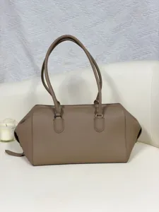 Taupe leather bowling bag detail, minimalist design, premium leather texture, elegant shoulder strap.