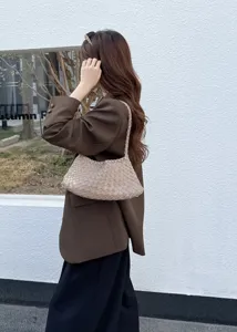 Handmade woven leather shoulder bag detail, stylish women hobo handbag lifestyle display scene.