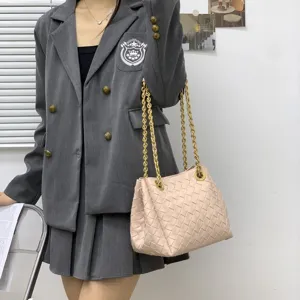 Détail de sac porté épaule tressé, sac seau rose élégant avec chaîne dorée pour femmes.