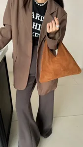 Vue détaillée d'un sac triangle sous les aisselles en daim marron au style minimaliste.