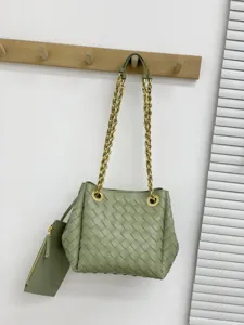 Sac seau en cuir tressé à la main avec bandoulière chaîne dorée et petite pochette.