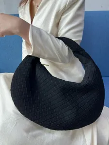 Black woven shoulder bag detail, featuring a stylish frosted texture and slouchy underarm style.