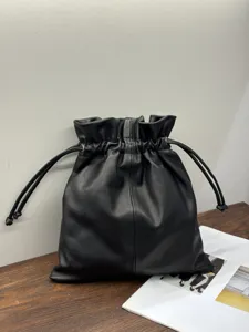 Detail shot of the black leather drawstring bucket bag showing soft texture and fine stitching.