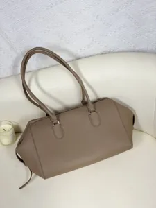 Detailed view of the taupe leather bowling bag featuring pebble texture and silver hardware.