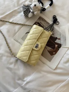 Quilted leather chain phone bag detailed view, elegant yellow crossbody shoulder bag.