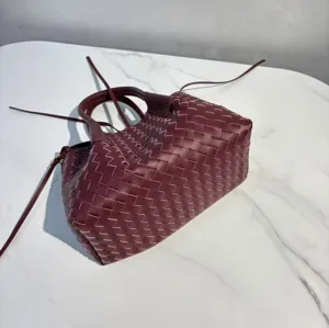 Burgundy leather woven handbag with top handles and stylish design for daily use.