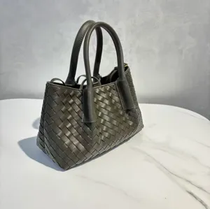 Detail view of dark grey woven leather tote handbag, premium cowhide daily shoulder bag.