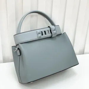 Light blue leather top handle bag featuring a studded strap, classic luxury retro style.
