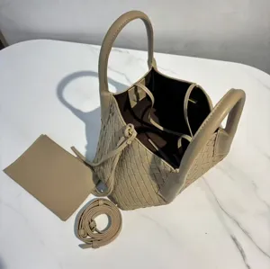 Detailed view of beige woven leather tote handbag with shoulder strap and matching pouch.