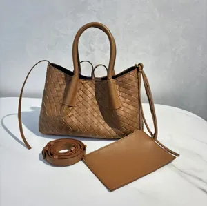 Detailed view of the brown woven leather tote bag with handles, long strap and matching pouch.