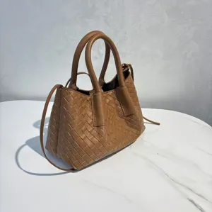 Detailed shot of the brown woven leather handbag showing fine craftsmanship and sturdy handles.
