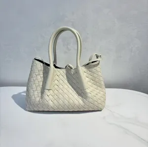 Close-up view of the exquisite woven leather detail and structured handles on the tote bag.