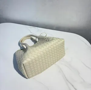 Detail shot of a beige genuine leather woven handbag, featuring classic intrecciato design.