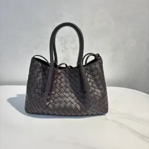 Dark brown woven leather handbag detail showing classic intrecciato craftsmanship and handles.