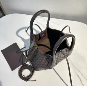 Detail view of the dark brown woven leather tote bag interior, showing large capacity and strap.
