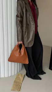 Sac à main triangle en cuir marron détail montrant design unique de sac sous les bras vintage.