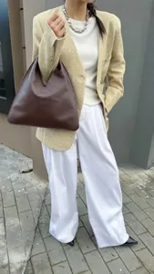 Vue détaillée du sac bandoulière triangulaire en cuir marron, style urbain très chic.
