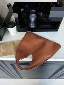 Sac à main triangulaire minimaliste en cuir marron, sac hobo chic épaule pour femme élégante.