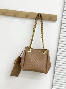 Sac seau tressé en cuir fait main avec bandoulière chaîne en métal et pochette détail.