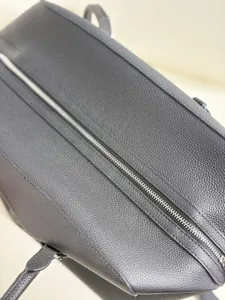 Close-up detail of black leather EW bowling bag minimalist tote bag daily commute.