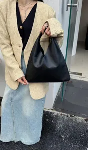 Sac porté épaule minimaliste en cuir noir triangulaire, cabas élégant et souple pour femme.