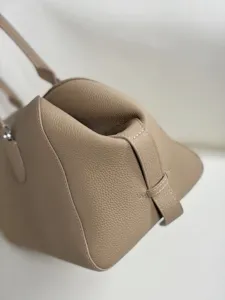 Detailed close-up of taupe genuine leather shoulder bag, highlighting texture and stitching.