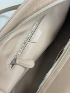 Close up of leather handbag interior zipper pocket, displaying premium texture and stitching.