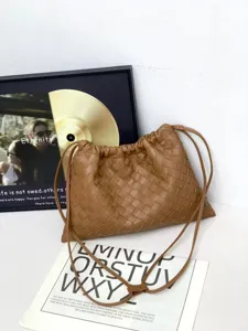 Brown woven leather shoulder bag detail view, casual drawstring design, premium material close up.