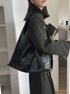 Minimalist black soft leather shoulder tote bag detail shot, large capacity daily use.