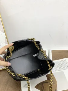 Vue détaillée du haut de l'intérieur du sac seau tissé en cuir noir avec chaîne.