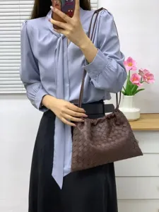 Brown leather woven shoulder bag for women, stylish crossbody pouch with drawstring design.
