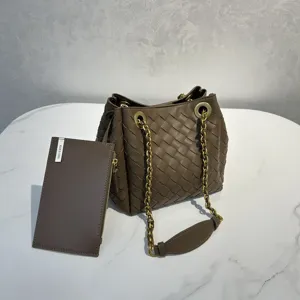 Sac seau en cuir tressé à la main avec bandoulière chaîne et petite pochette chic.