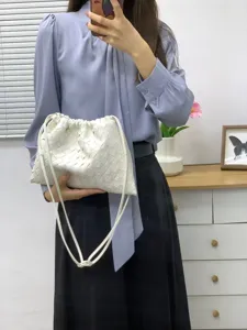 White woven leather pouch bag detail, soft cloud design with delicate drawstring closure.