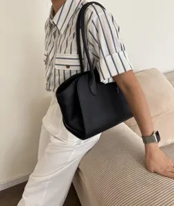 Detailed view of the black leather tote bag showcased in a minimalist lifestyle setting.