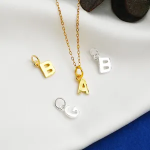 Close-up of S925 sterling silver alphabet pendants in gold and silver finishes.