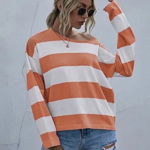 Close-up view of a casual loose fit sweater with orange and white horizontal stripes
