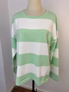 Detailed macro view of green and white horizontal striped knit sweater with round neck style