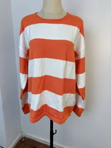 Detail showing the front of a cozy orange and white striped long-sleeved knit sweater