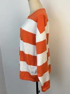 Detailed side view of casual orange and white striped loose knit sweater on mannequin