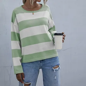 Casual loose knit sweater with green and white stripes, paired with blue ripped jeans