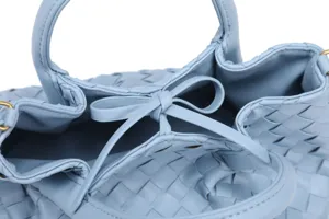 Close-up detail shot of the elegant light blue woven leather handbag showcasing craftsmanship.