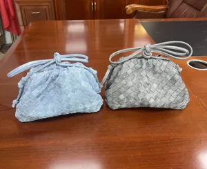 Woven cloud clutch bag detail, stylish intrecciato style handbag in blue and gray.