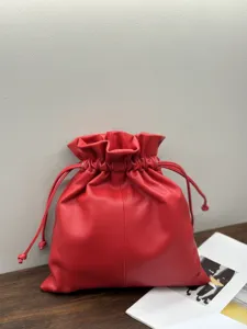 Red genuine leather pouch bag detail, minimalist drawstring cloud handbag for women.