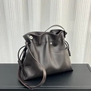 Bolso saco de cuero suave marrón oscuro con cierre de cordón y elegantes detalles de nudos en los lados.